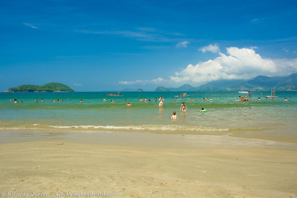 Imagem de vários turistas nas águas calmas da Praia da Almdada.